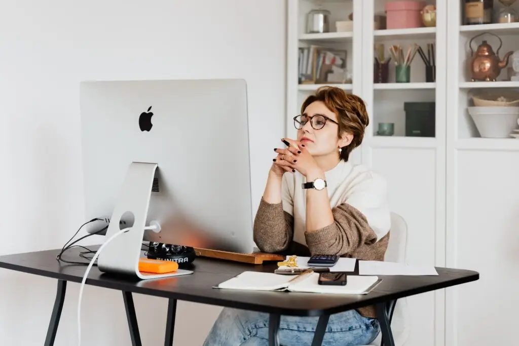 Focused female employee reading information on computer in office